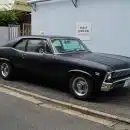 black sedan parked on sidewalk during daytime