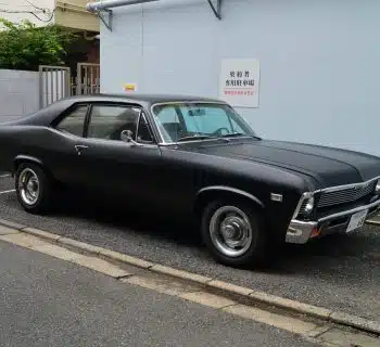 black sedan parked on sidewalk during daytime