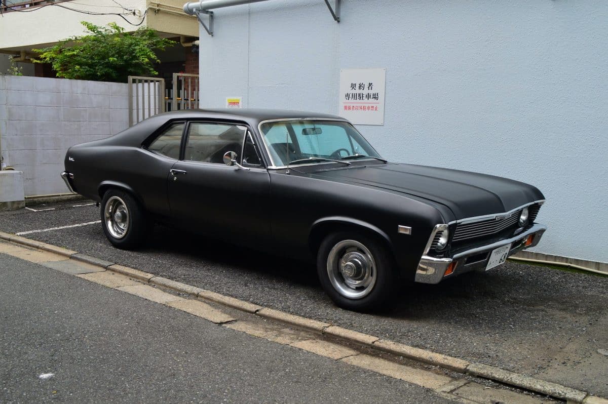 black sedan parked on sidewalk during daytime